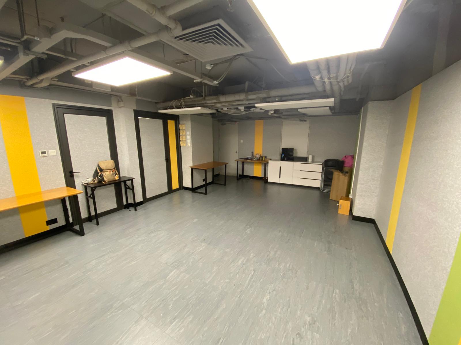 Easy Solution Training Room — open floor plan, green & yellow ribbon walls, drop ceiling, side counter and entry doors